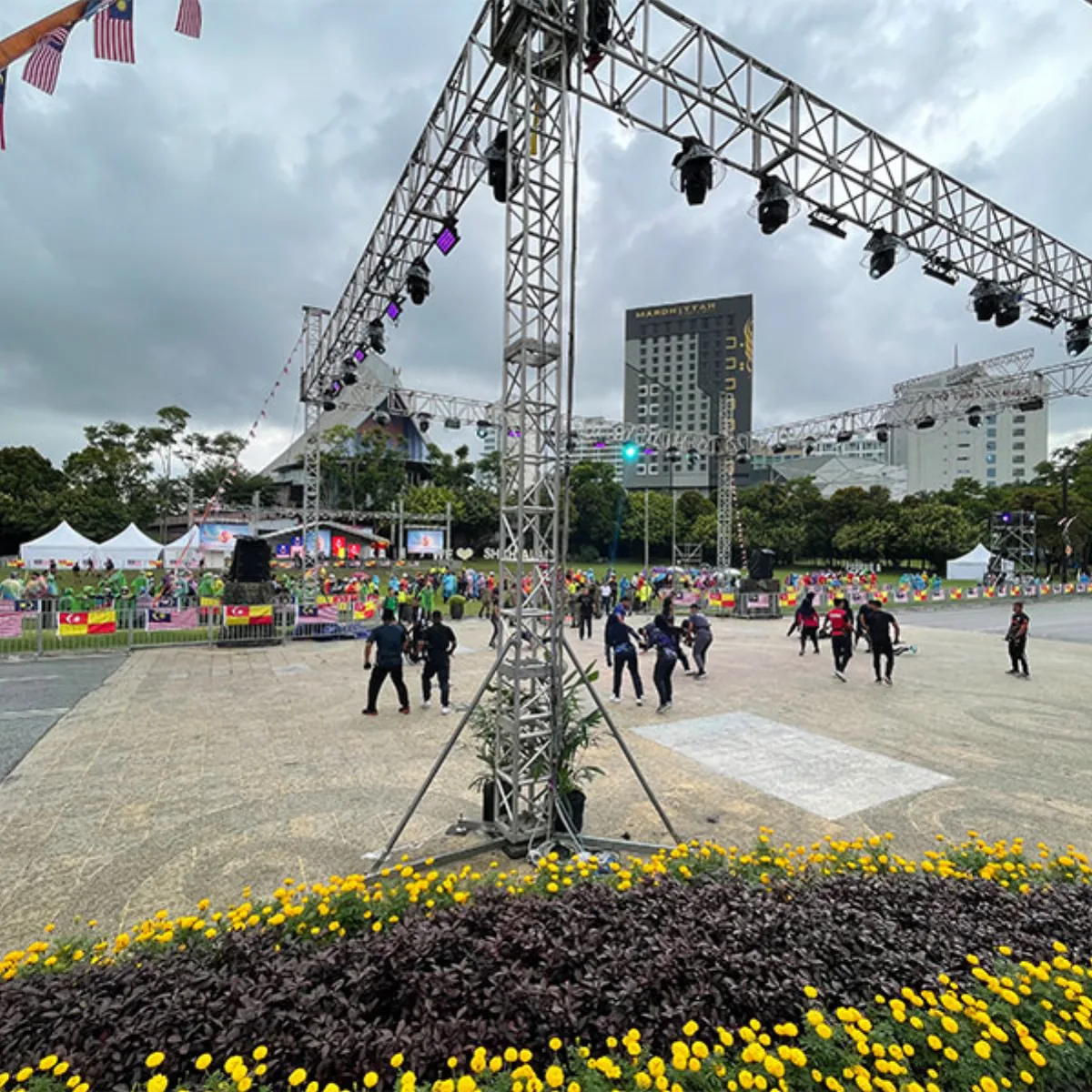 Outdoor event site with stage truss and landscaped foreground
