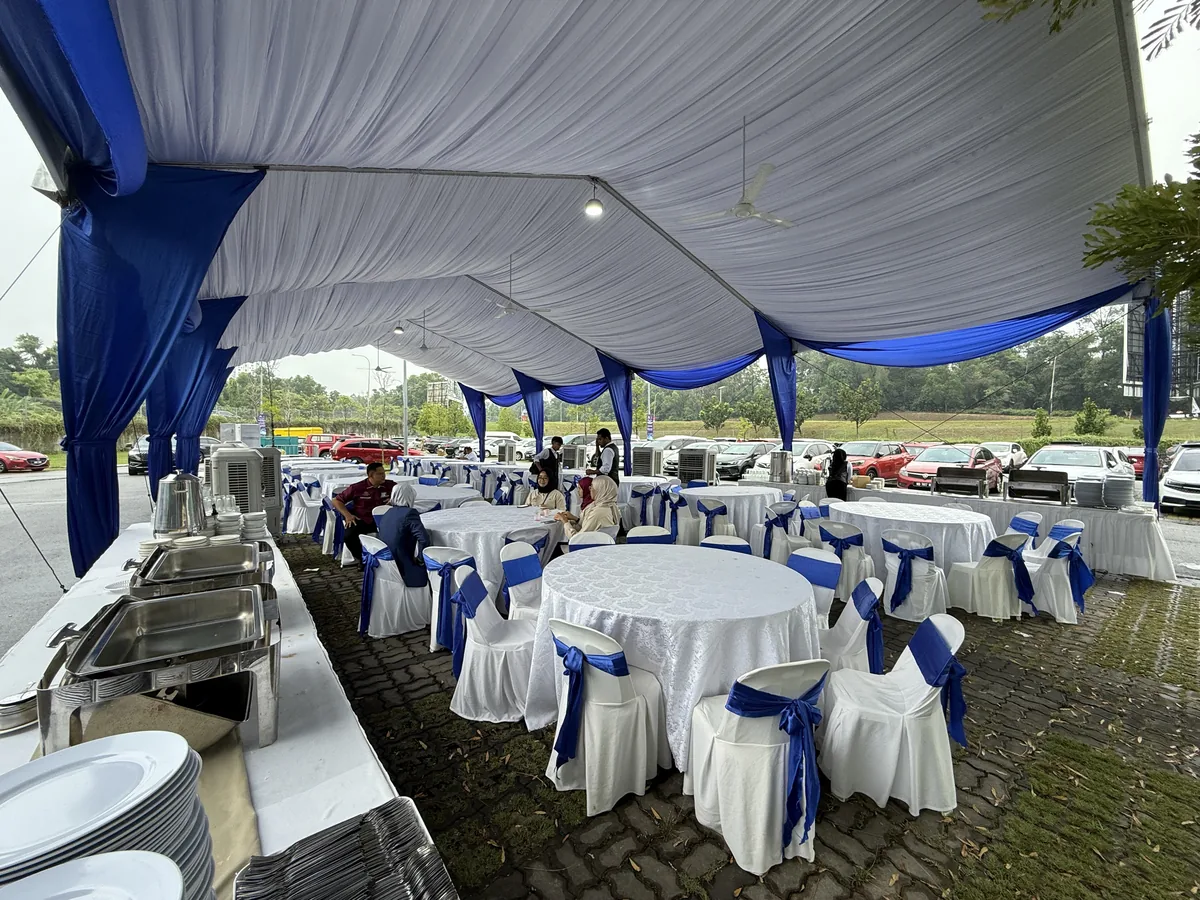 White marquee with blue draping, set tables and a buffet line