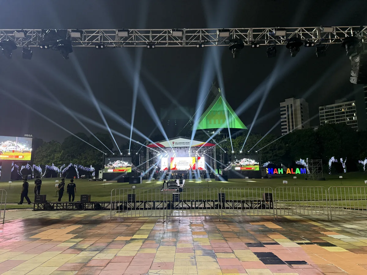 White light beams over a night stage with LED screens