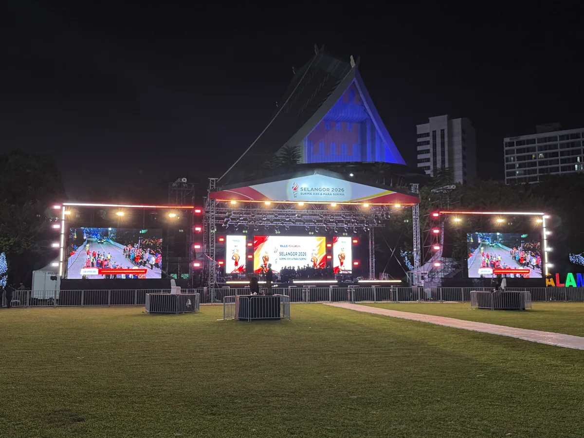 Lawn stage at night with three LED screens and lit truss